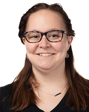 Headshot of a woman with brown hair and glasses