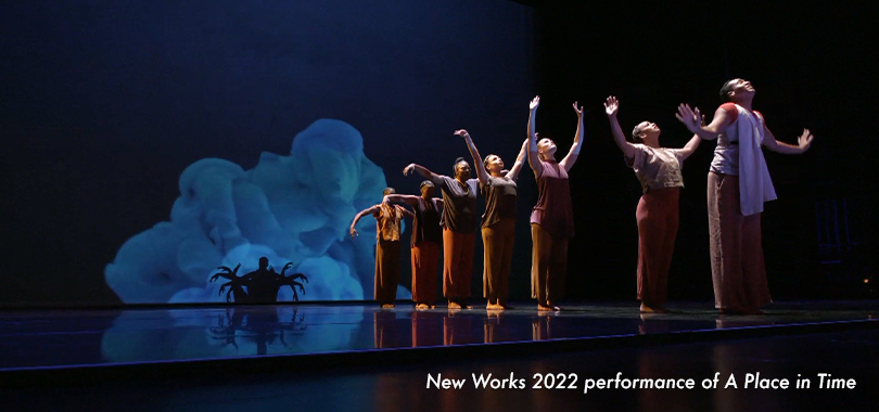 New Works 2022 performance of A Place in Time. Dancers form a line in front of a projection of billowing smoke.