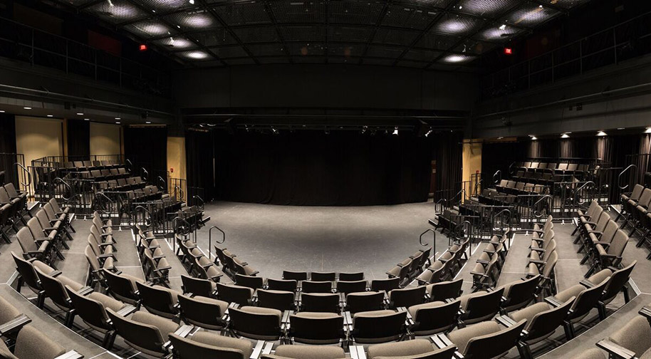 A wide-angle view of the black box Studio Theater from the last row of seating.