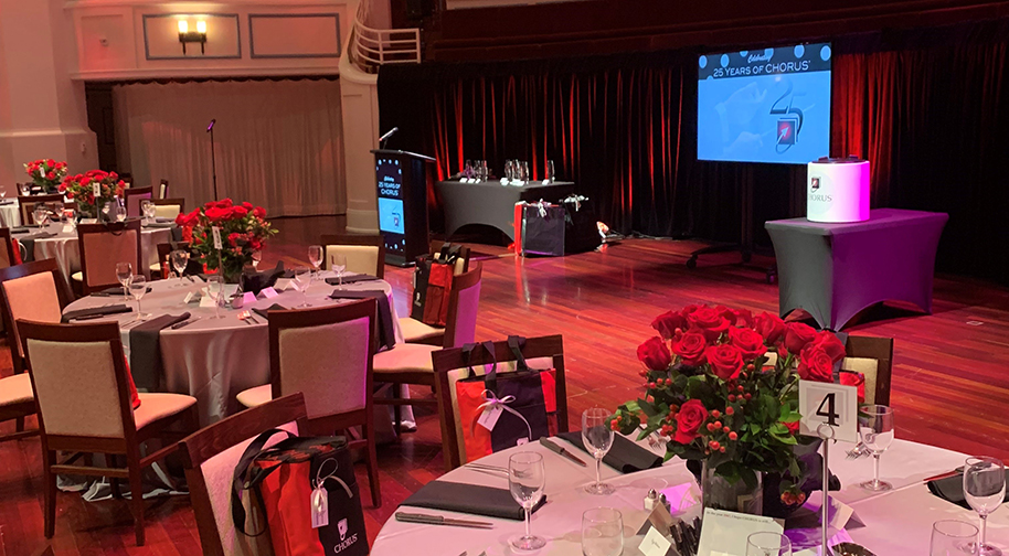 A corporate event on the Palladium stage. Gift bags are prepared at the seats surrounding circular dining tables.