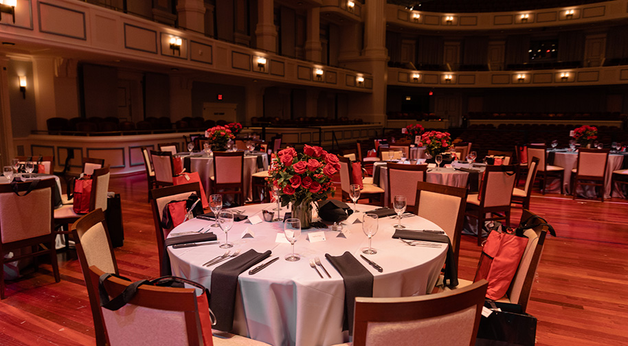 Dining tables arranged on the Palladium stage for a party.