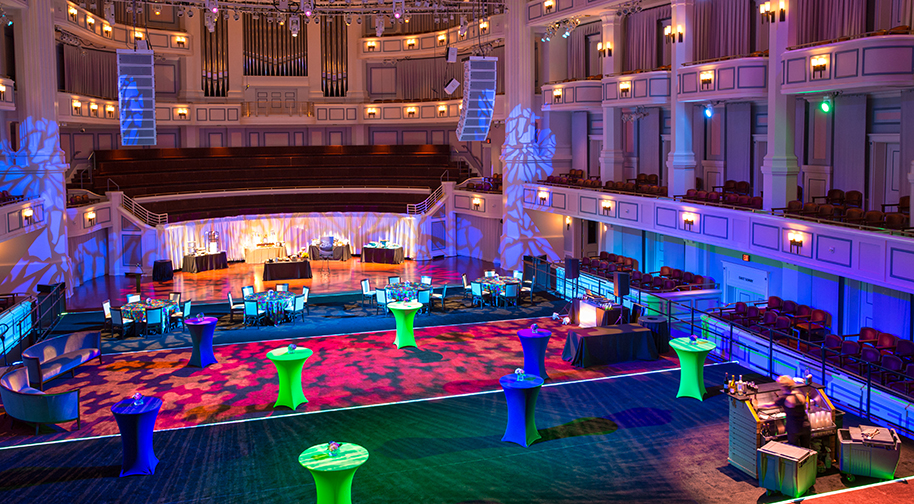 Brightly colored cocktail tables scattered on the festival flooring in the Palladium concert hall.