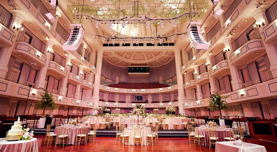 An elegant wedding in the Palladium concert hall. Festival flooring covers the main level seating to accomodate tables.