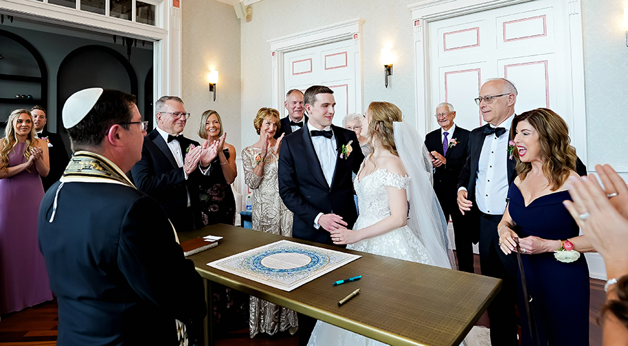 A wedding party celebrates as the ceremony ends inside the Founders Club.