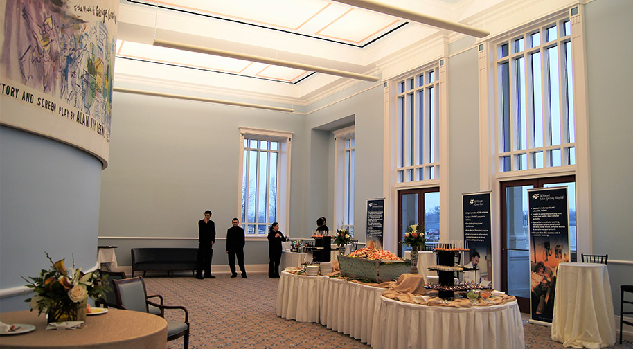 The Robert Adam Room in the Palladium is prepared for a party with a large buffet and cocktail tables.