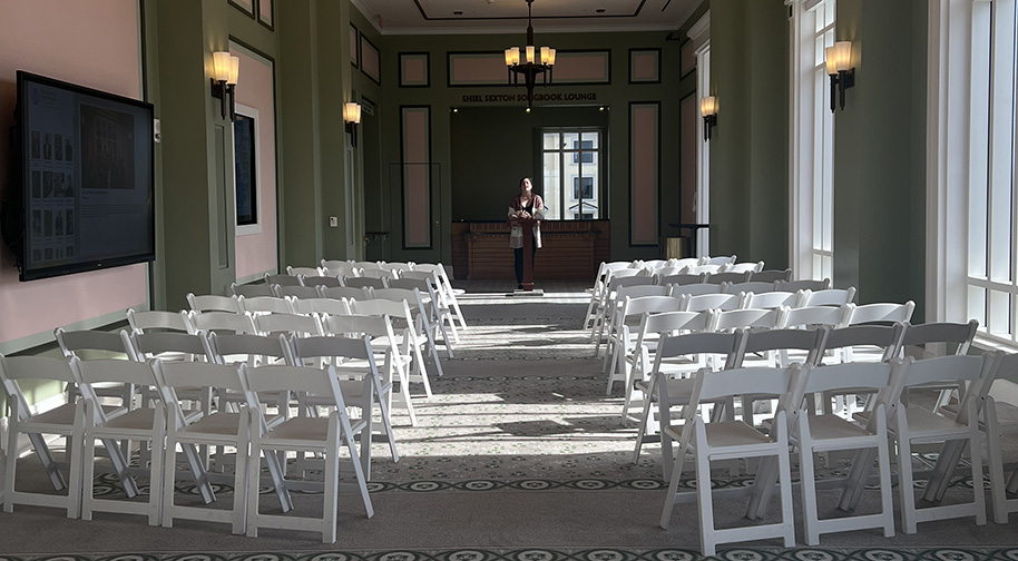 The Shiel Sexton Songbook Lounge at the top level of the Palladium is filled with white chairs and a podium for a small presentation.