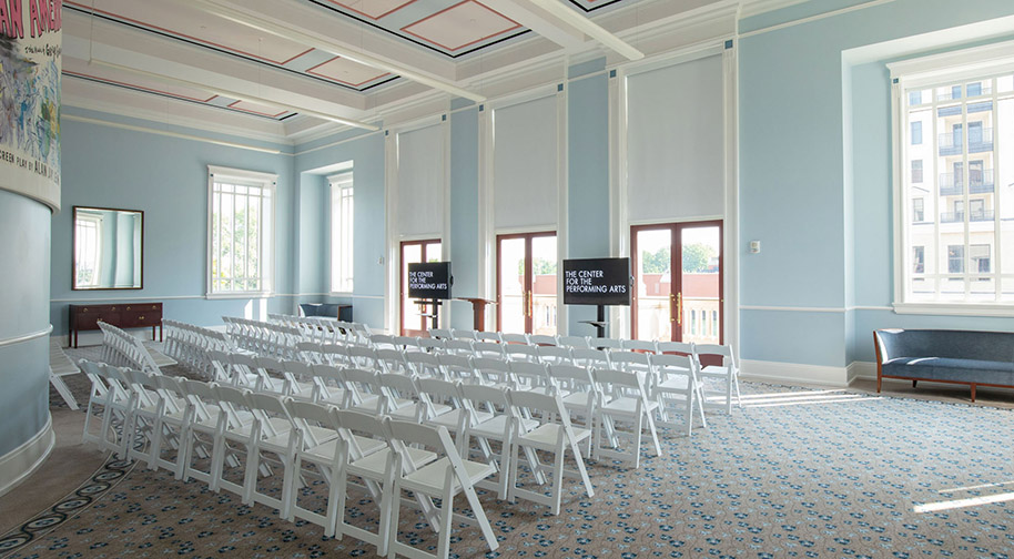 White chairs for 100 and two presentation screens arranged in the Shiel Sexton Songbook Lounge.