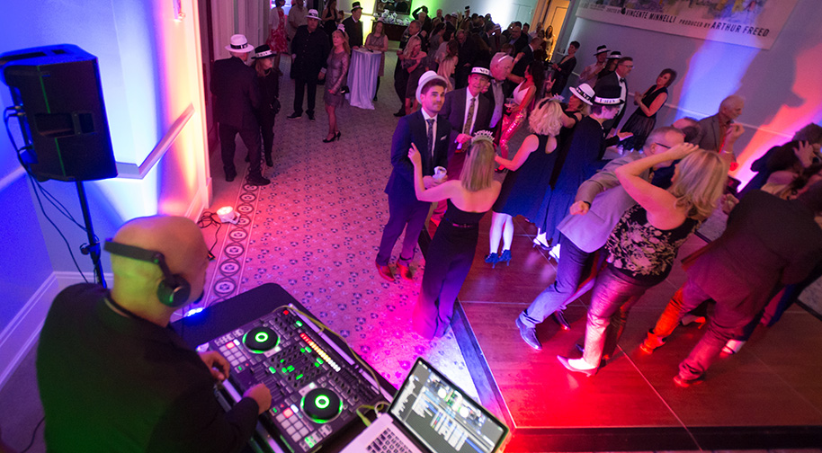 The Robert Adam Room in the Palladium is filled with party-goers. A DJ and dance floor are set up on one side.