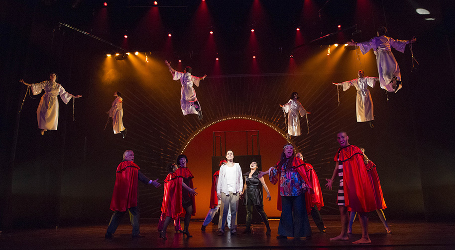 In a musical production on the Tarkington stage, cast members fly with their arms outstretched.