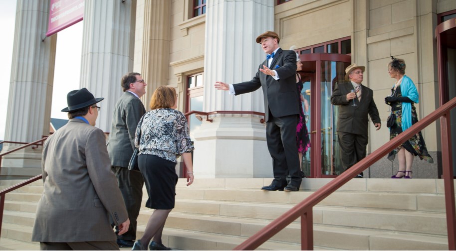 Patrons in fancy dress are greeted by a volunteer usher at the South entrance of the Palladium.