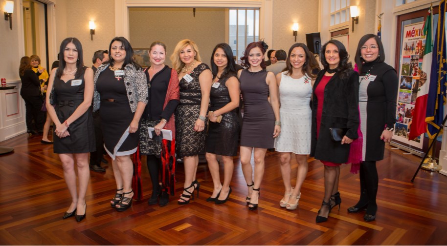 A group of nine professional women pose in a line during an event in the Palladium.