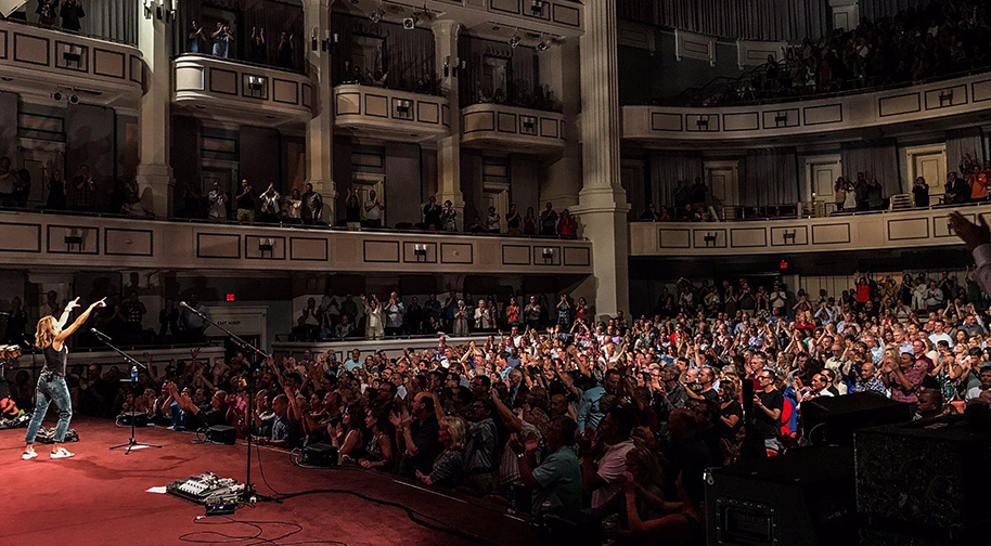 Sheryl Crow points with both hands out to a sold out audience during her Palladium performance.