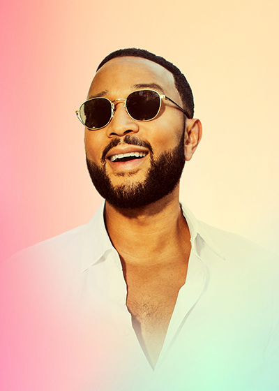 Musician John Legend smiling and wearing sunglasses.