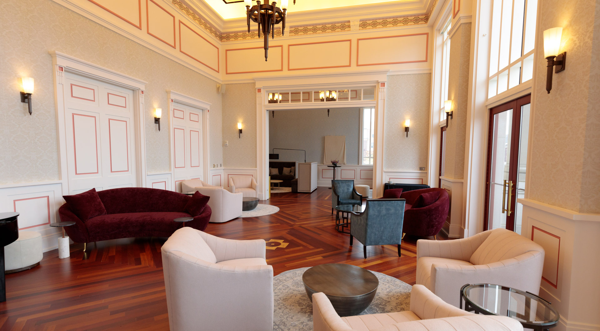 The Founder's Club, an elegant lounge area with chandeliers, sconces, polished hardwood floors and plush furniture.