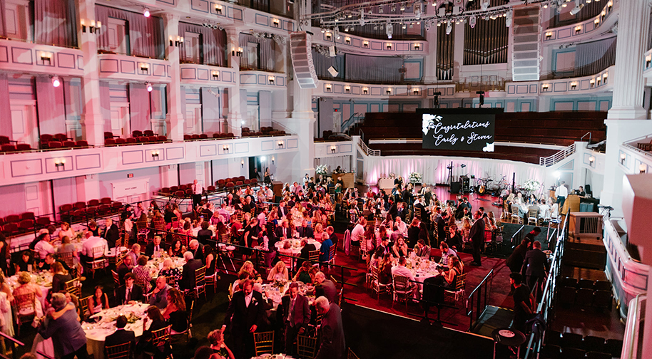 An elegant wedding in the Palladium concert hall. Festival flooring covers the main level seating to accomodate tables.