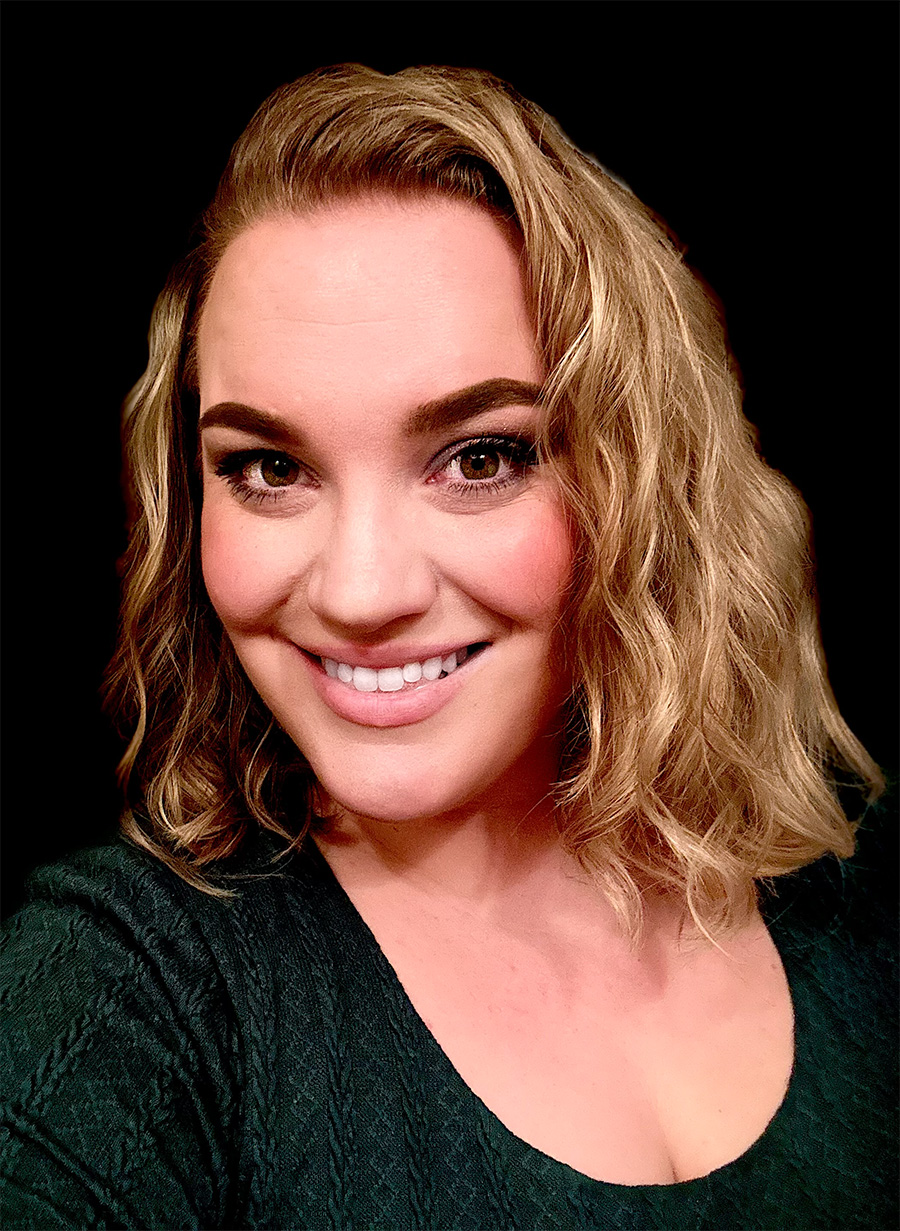 A woman with shoulder-length brown hair smiles at the camera