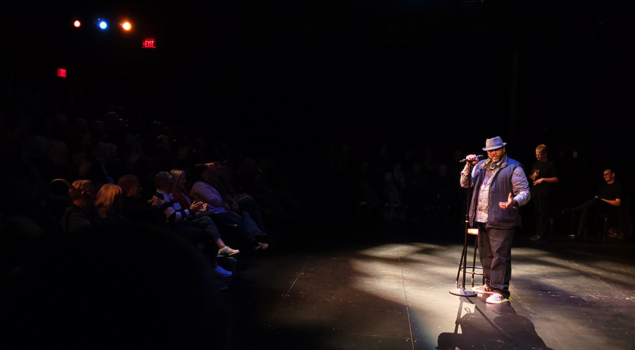 A Stand-Up Comedy Class student delivers his set for an audience in the Studio Theater as part of the graduation performance.